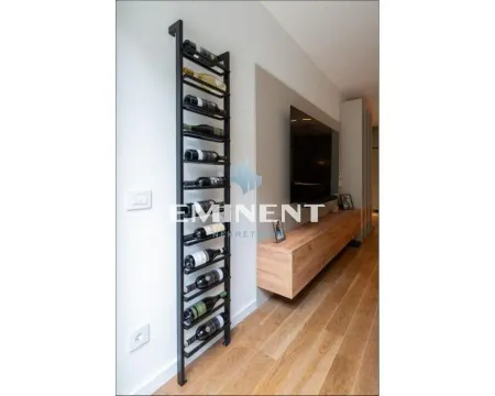 Living room with wooden flooring, TV and a wine rack. - image 3