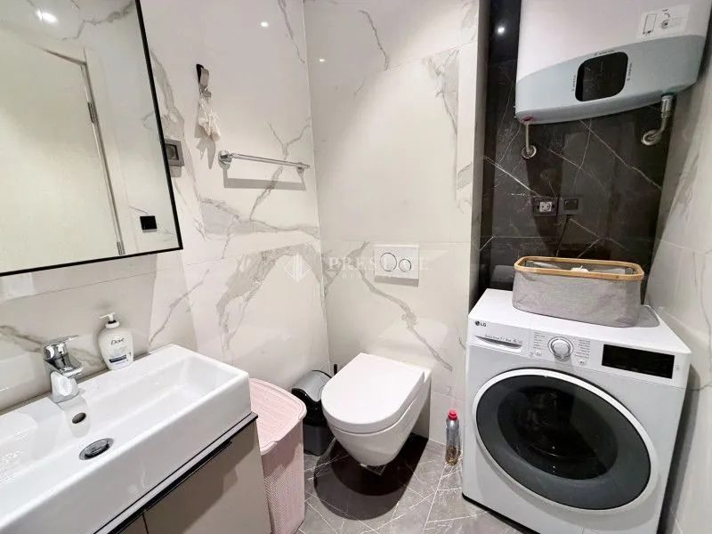 Modernly equipped bathroom with a washing machine.