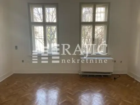 Empty room with parquet flooring and two windows. - image 4