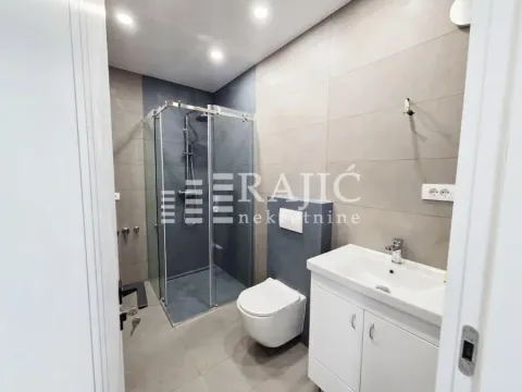 Modernly equipped bathroom with a shower cabin and a washbasin. - image 9