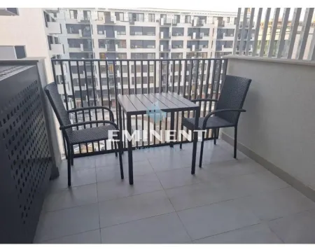 Namešten balkon sa stolom i dve stolice i pogledom na zgrade. - image 15