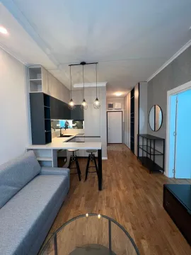 Modern living room with a kitchen and dining area in light tones. - image 9
