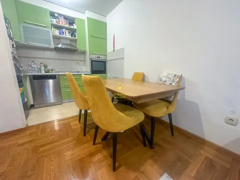 Trpezarija sa stolom i žutim stolicama i pogledom na kuhinju. - image 2