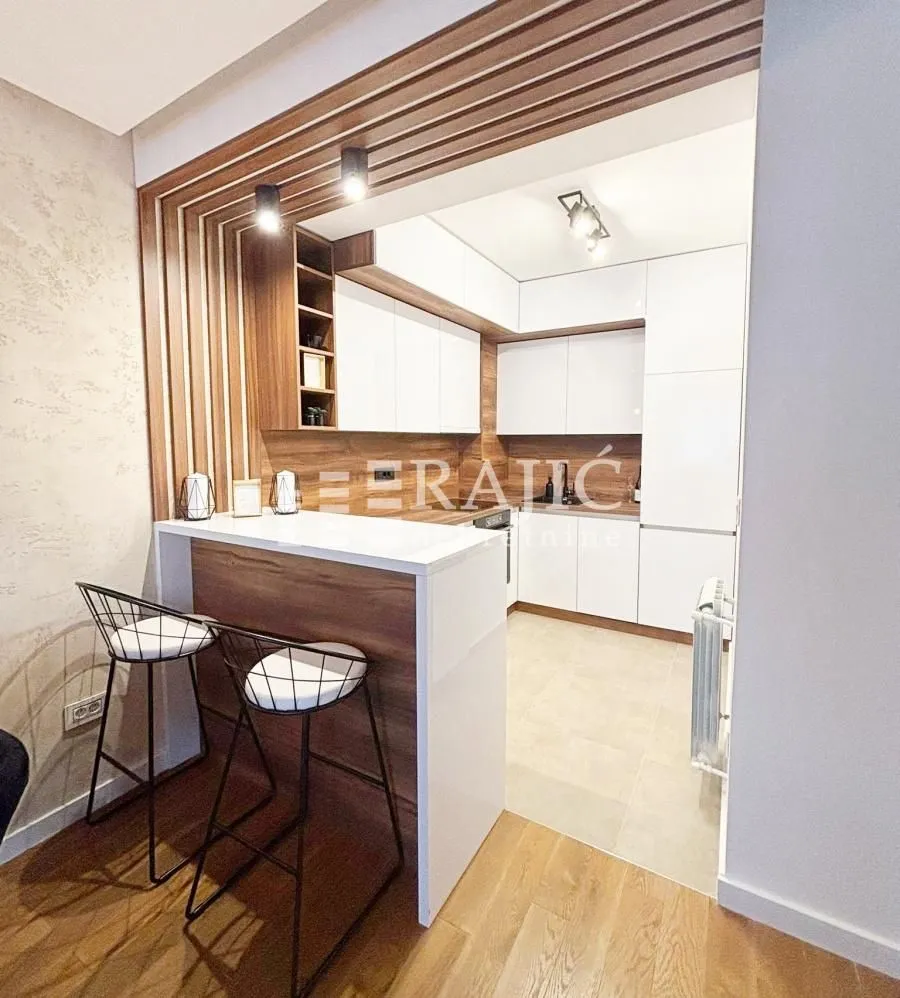 Modern kitchen with a breakfast bar and white cabinetry.