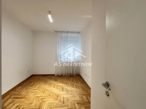 Prazna soba sa parketom i belim zidovima. - image 11
