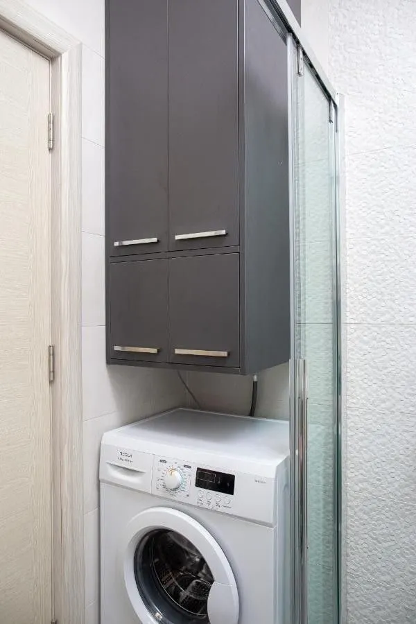 Bathroom with washing machine and wall cabinet.