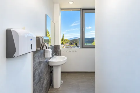 Modernly equipped bathroom with a washbasin, mirror, and soap and paper dispensers. - image 11