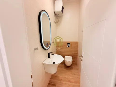 A modern bathroom equipped with a sink, mirror, and toilet bowl. - image 5