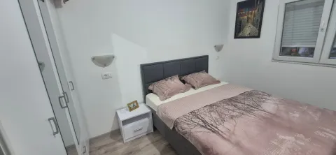 Namještena spavaća soba sa bračnim krevetom, bijelim garderoberom i noćnim stočićem. - image 2