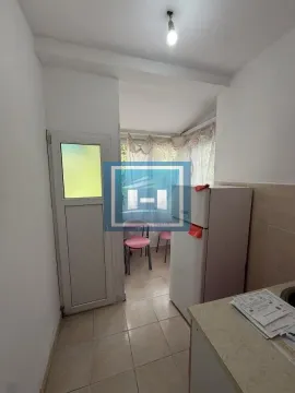 Pogled na manju kuhinju sa frižiderom i izlazom na zastakljenu terasu. - image 3