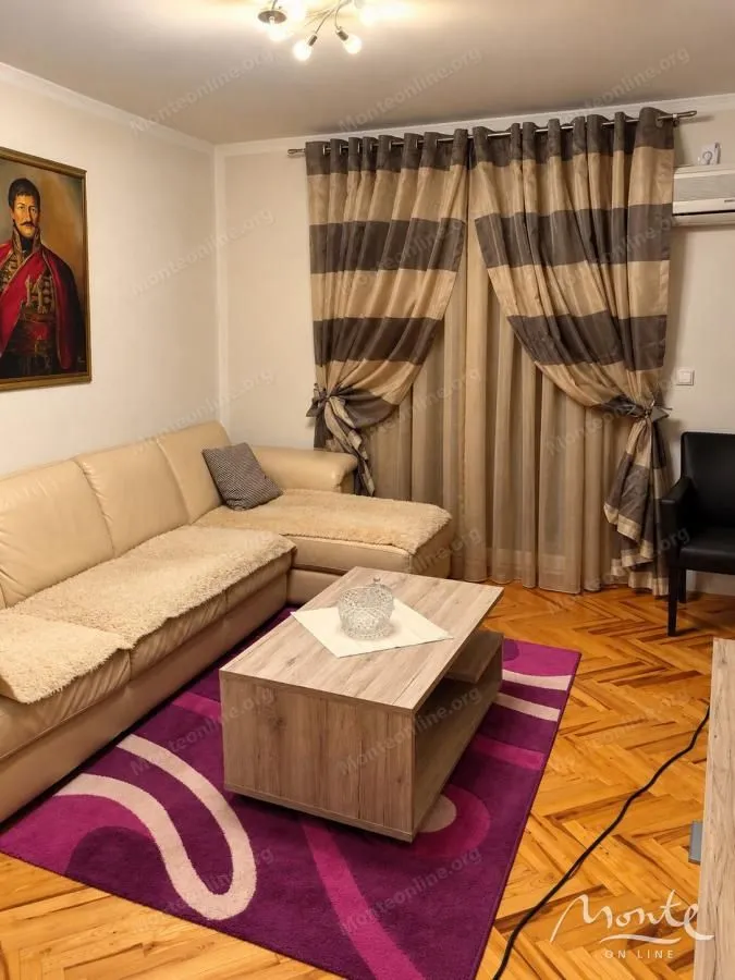 Living room with a sectional sofa, coffee table, and parquet flooring.