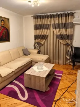 Living room with a sectional sofa, coffee table, and parquet flooring. - image 5