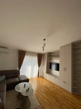 Living room with a sofa, TV unit, and hardwood flooring. - image 3