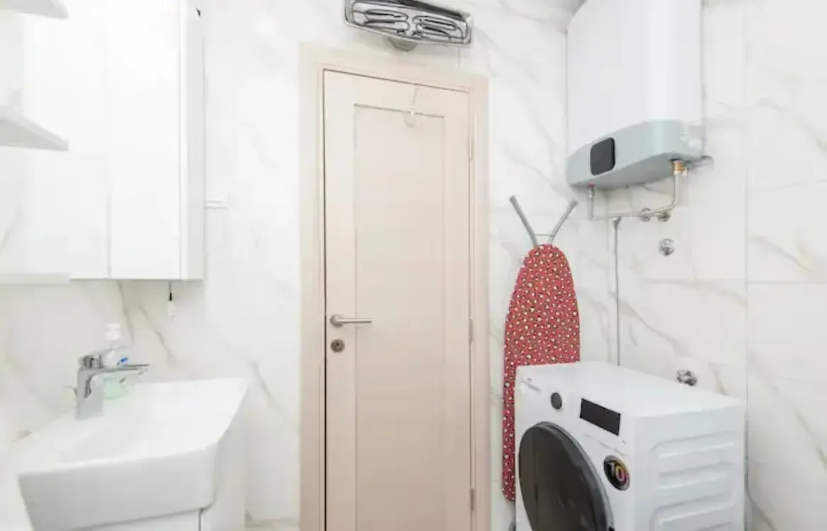 Bathroom with a washbasin, washing machine and water heater.