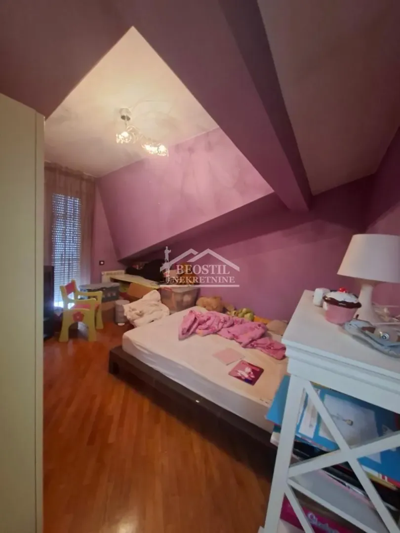 Attic bedroom with a bed and purple walls.