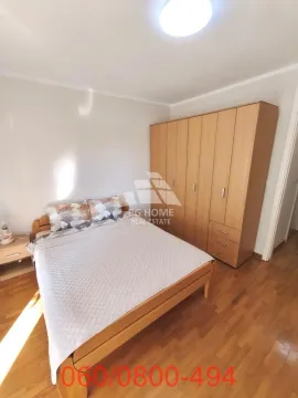 Nameštena spavaća soba sa bračnim krevetom i drvenim ormanom. - image 11