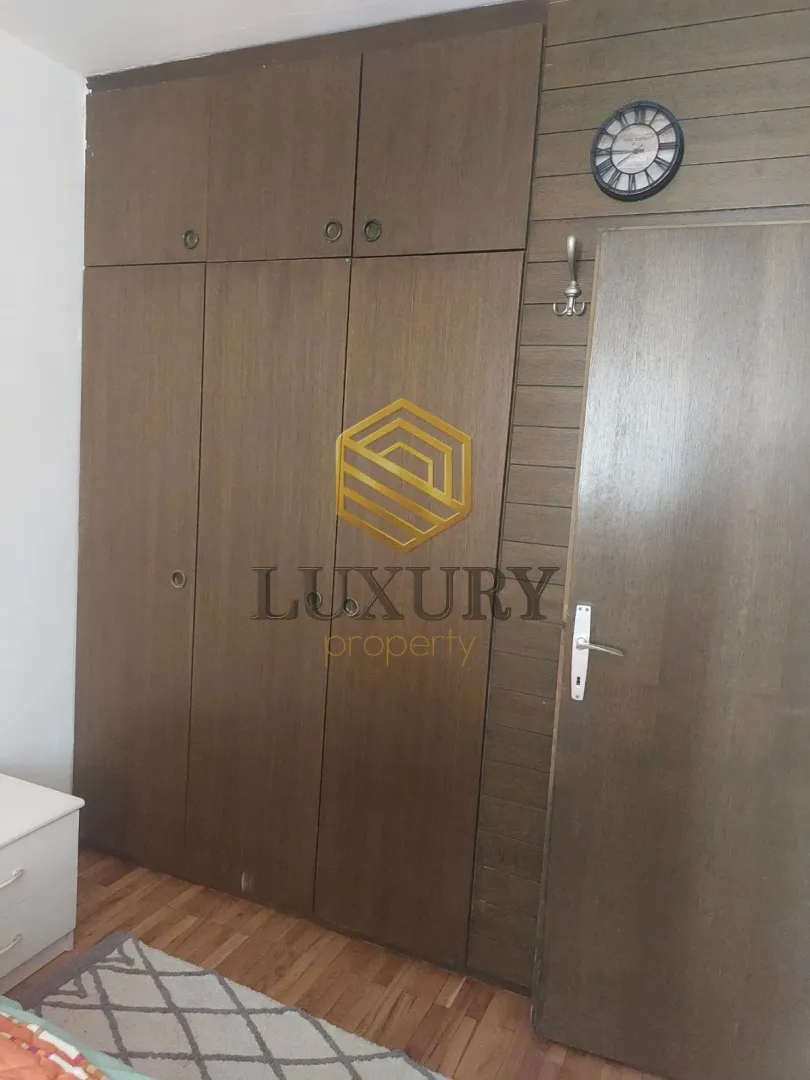 Bedroom with a built-in wardrobe and wooden wall paneling.