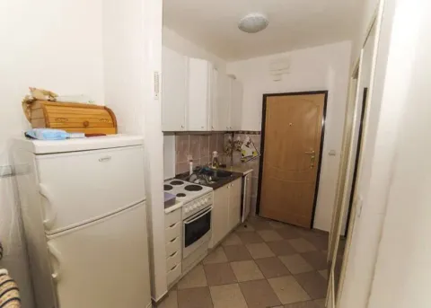 Small kitchen with white cabinets, refrigerator, and stove. - image 4