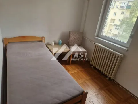 Manja spavaća soba sa krevetom, noćnim stočićem i prozorom. - image 9