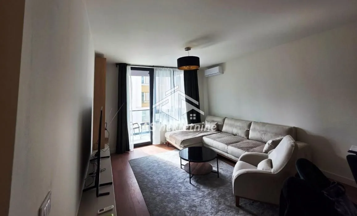 Living room with a sofa, armchair, and access to the terrace.