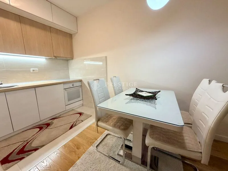 Modern kitchen with a dining table and white cabinets.