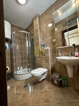 Kupatilo obloženo keramičkim pločicama sa tuš kabinom, umivaonikom i toaletom. - image 8