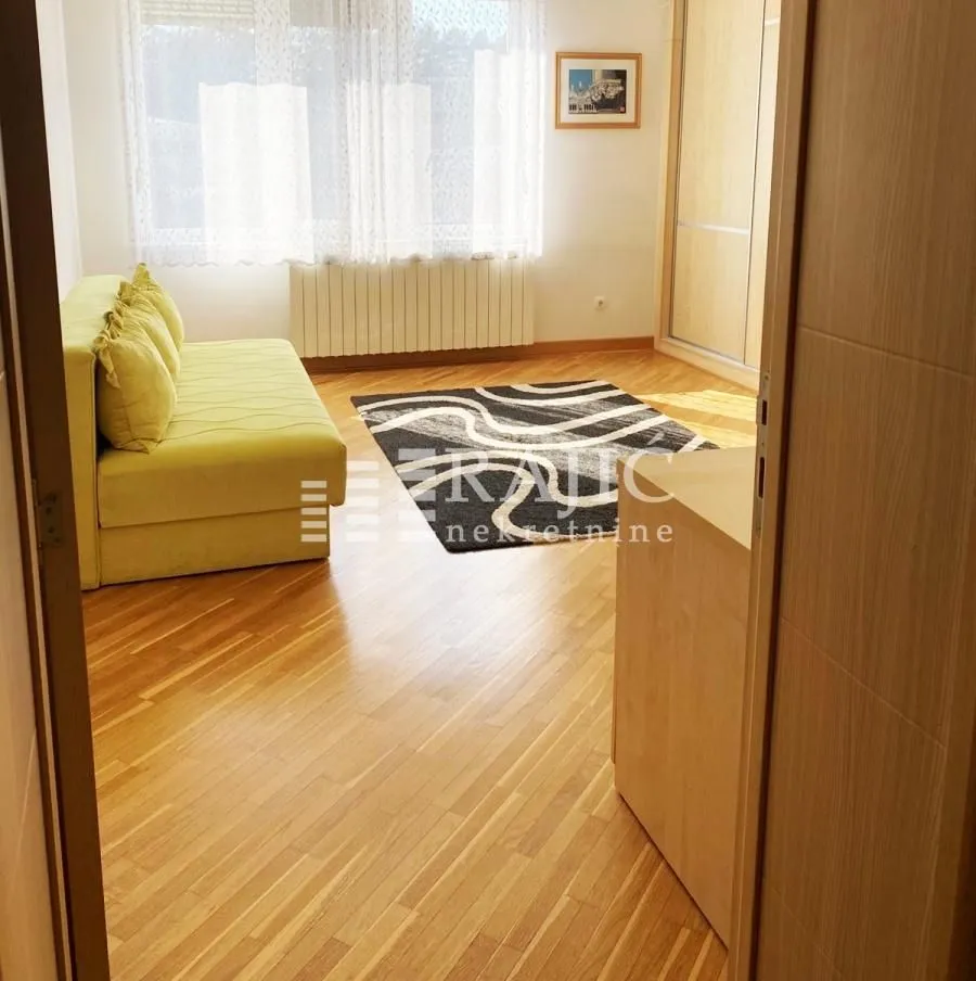 Living room with a sofa and parquet flooring.