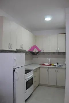 Small kitchen with white cabinets and appliances. - image 16