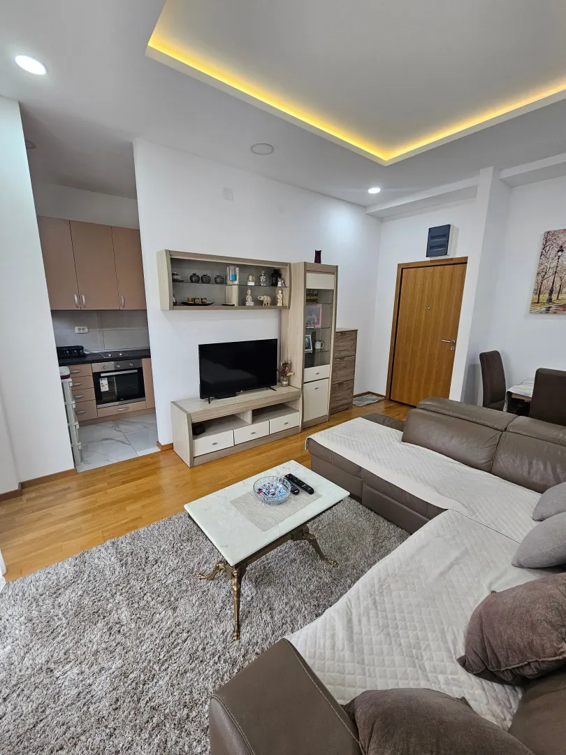 Spacious and bright living room with a sofa and TV unit.