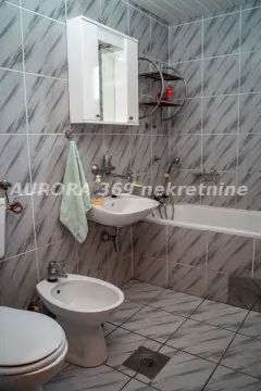 Bathroom equipped with sanitary ware, washbasin, bathtub, and marble-patterned tiles. - image 4