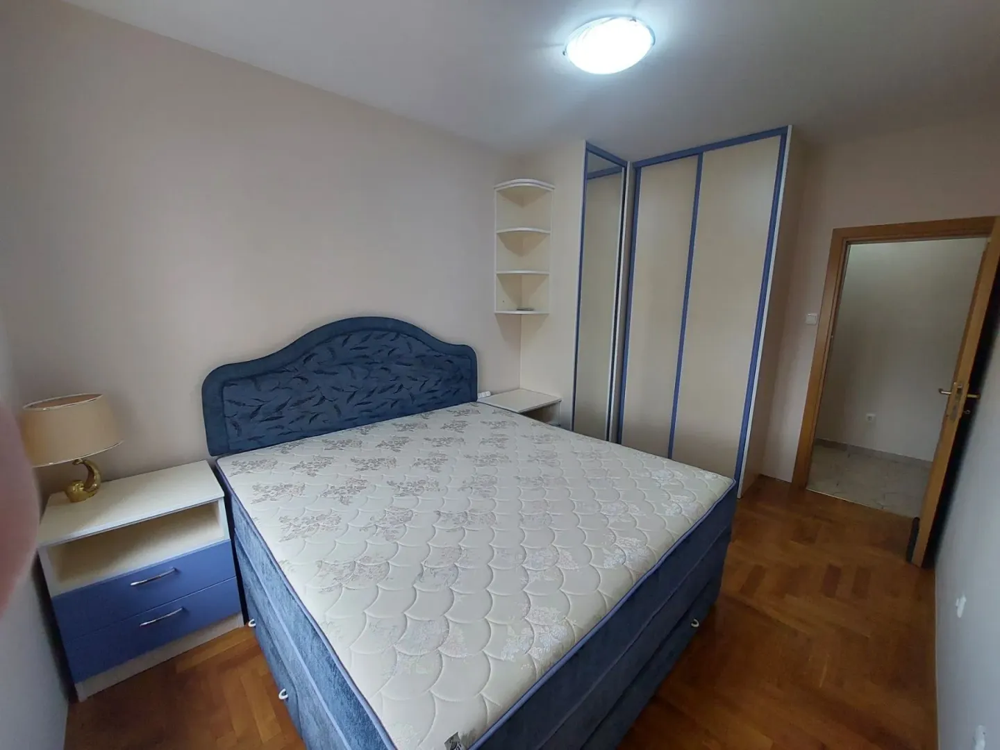 Bright bedroom with a double bed and a built-in wardrobe.