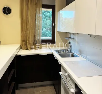 Smaller equipped kitchen with white cabinets and a built-in cooktop. - image 3