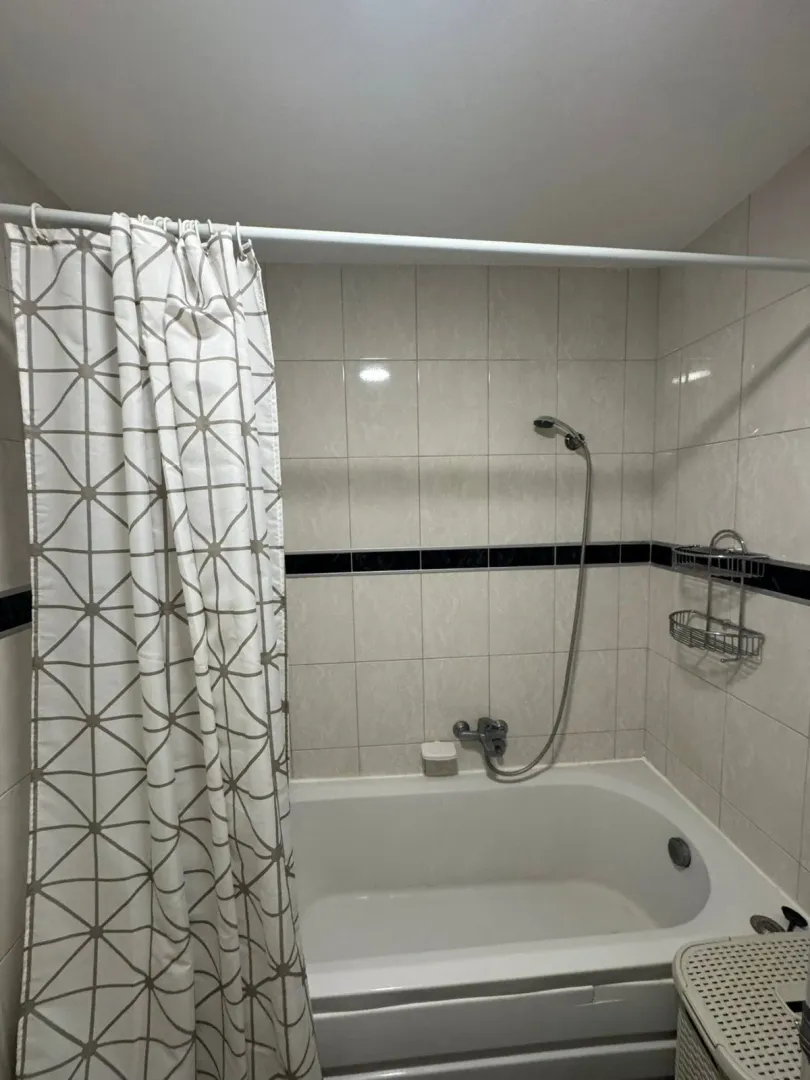 Bathroom with a bathtub and a shower curtain.