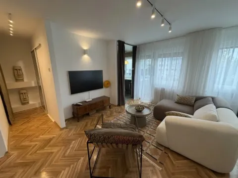 Dnevna soba sa garniturom, televizorom i drvenim podom. - image 13