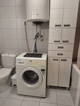Manje kupatilo sa veš-mašinom, bojlerom i bijelim elementima. - image 3