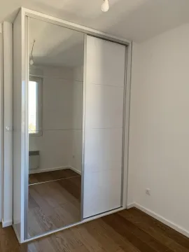 White built-in wardrobe with a mirrored sliding door in the room. - image 9