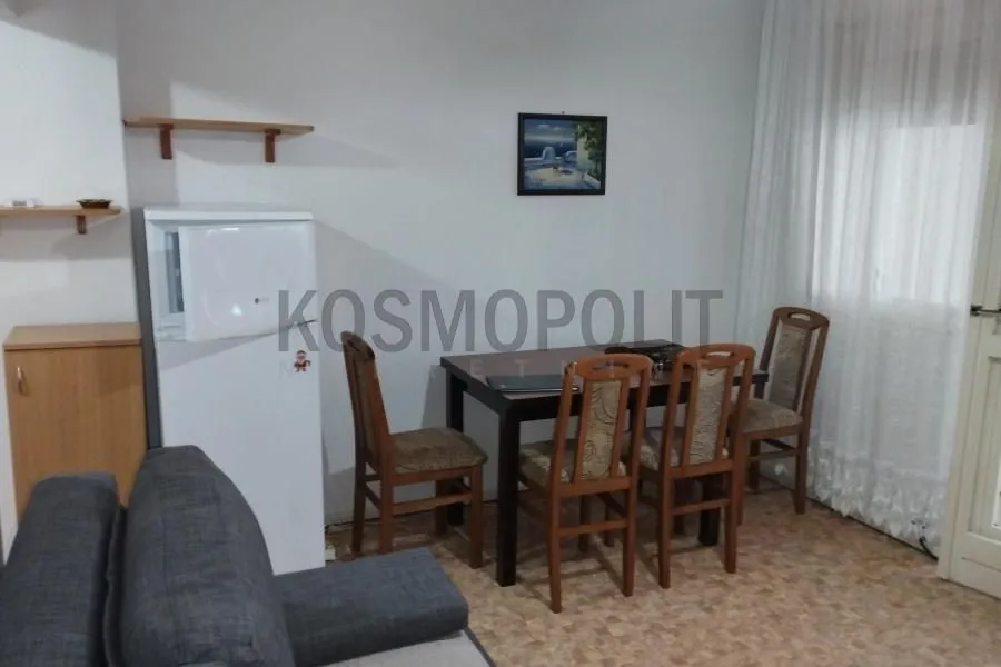 Living room with a dining table and refrigerator.