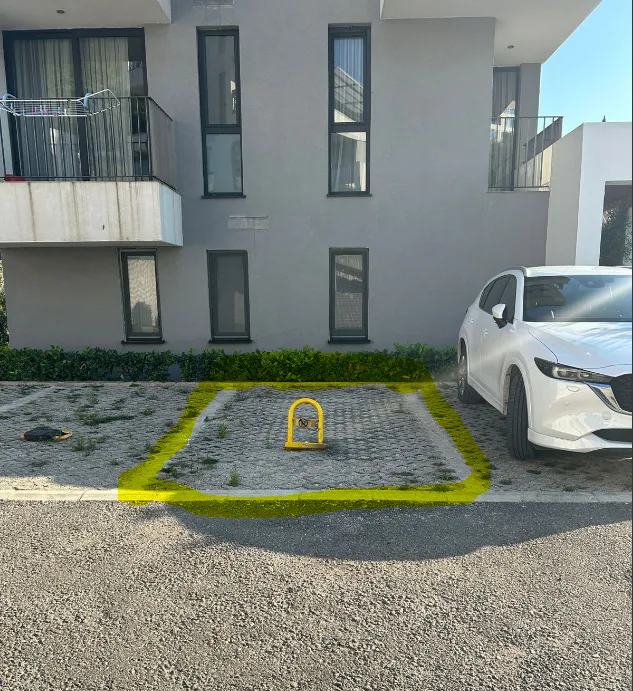 Parking mjesto ispred stambene zgrade sa označenim slobodnim prostorom.