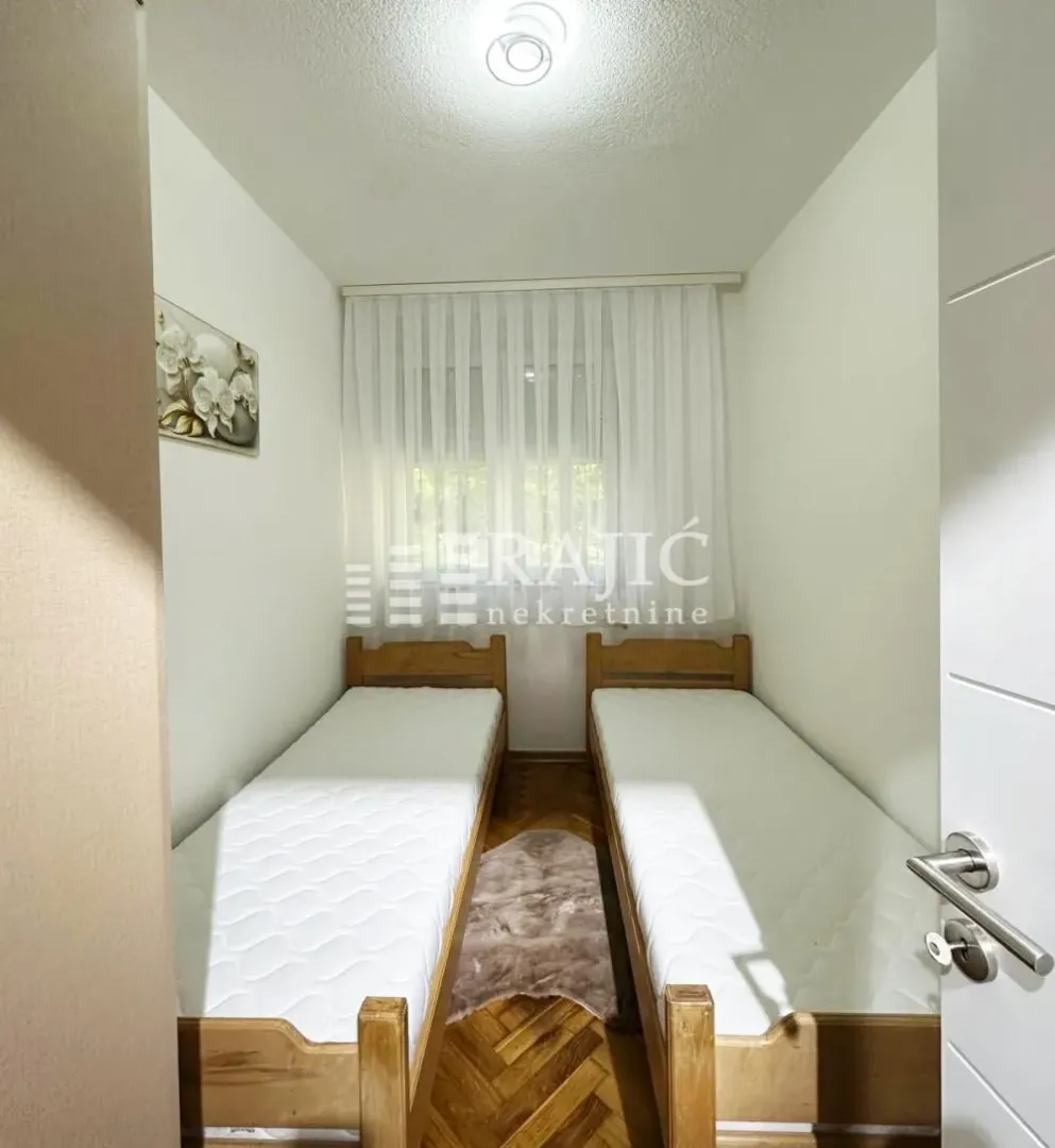 Small bedroom with two wooden beds.