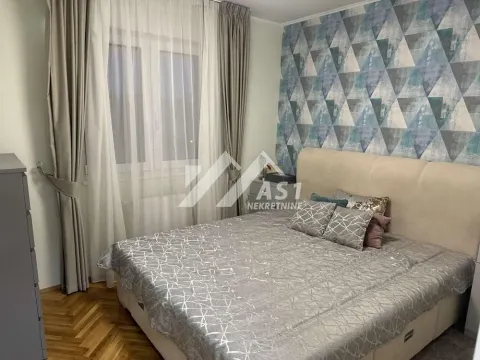 Nameštena spavaća soba sa bračnim krevetom, prozorom i dekorativnim tapetama na zidu. - image 4