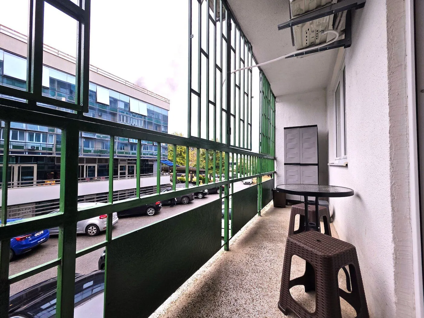 Enclosed balcony with a small table and chairs.