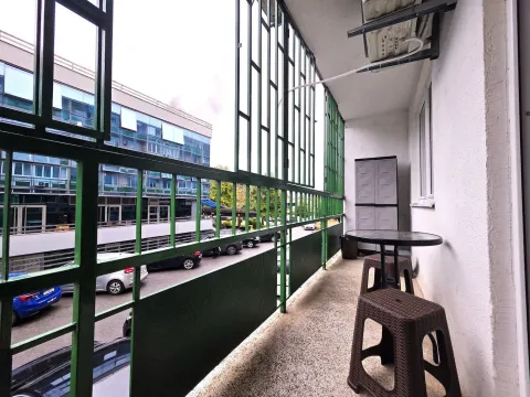 Enclosed balcony with a small table and chairs. - image 6