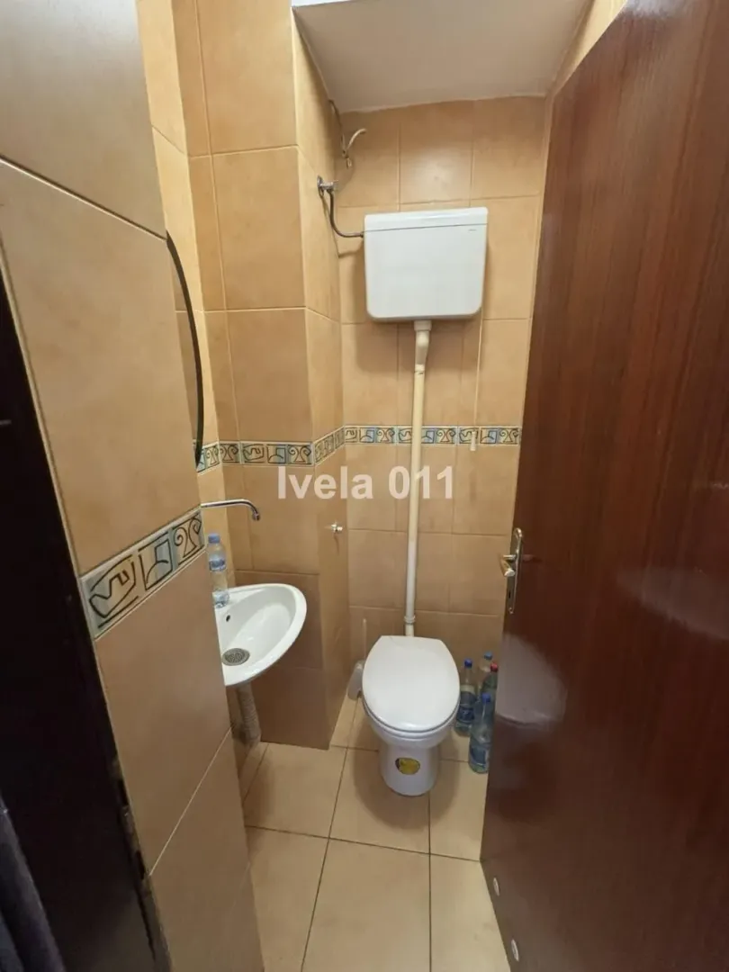 Manje kupatilo obloženo keramičkim pločicama sa WC šoljom i umivaonikom.