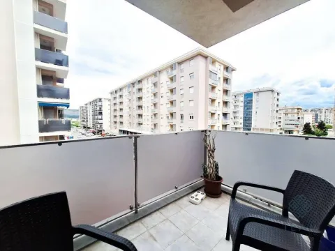 Small furnished balcony with a view of surrounding buildings and the city neighborhood. - image 11