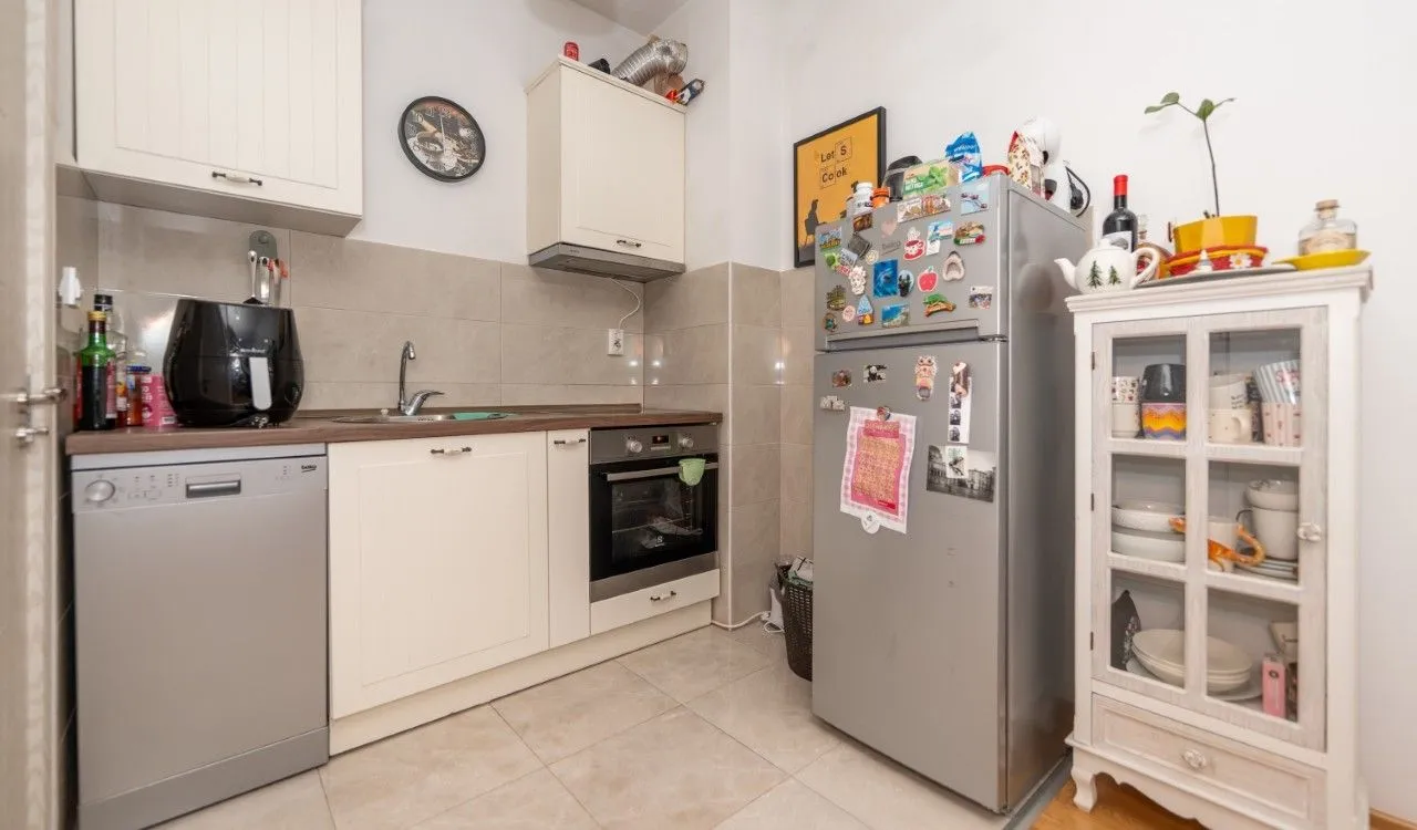 Compact kitchen with white cabinetry, refrigerator, and kitchen appliances.
