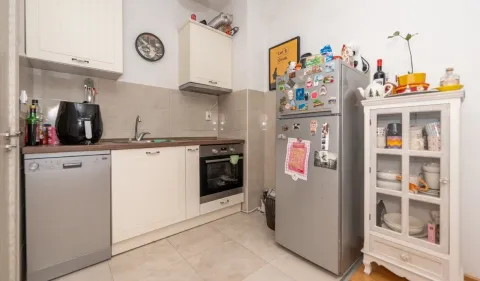 Compact kitchen with white cabinetry, refrigerator, and kitchen appliances. - image 4