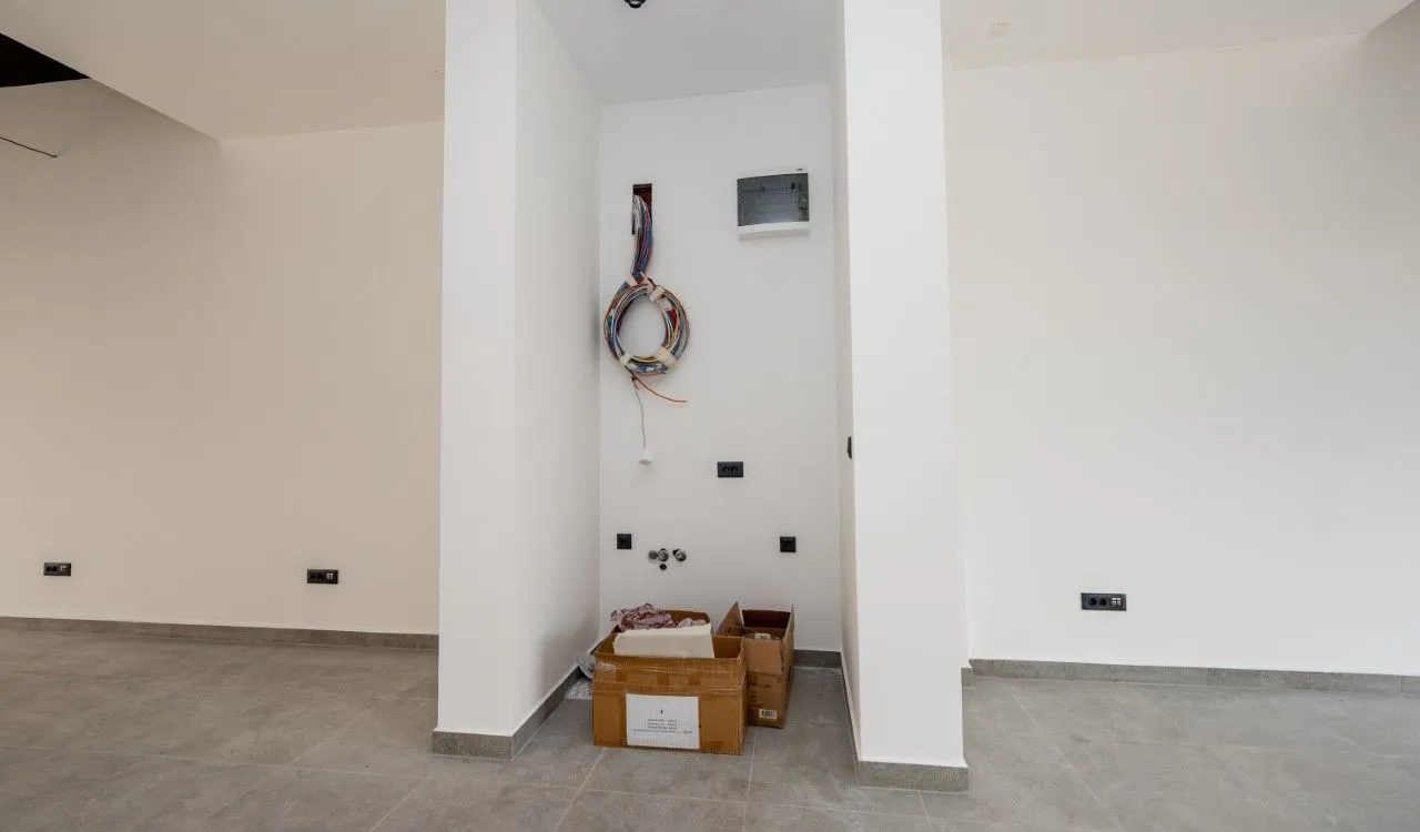 Empty room during construction work with wall installations and boxes on the floor.