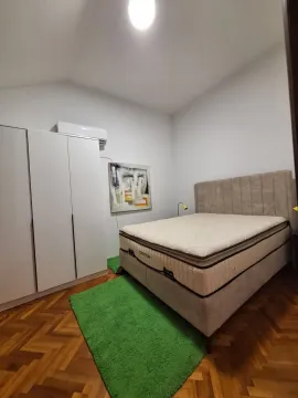 Bedroom with a double bed, white wardrobe, and parquet flooring. - image 14