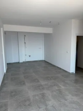 Prazna prostorija sa sivim podnim pločicama i bijelim zidovima. - image 6