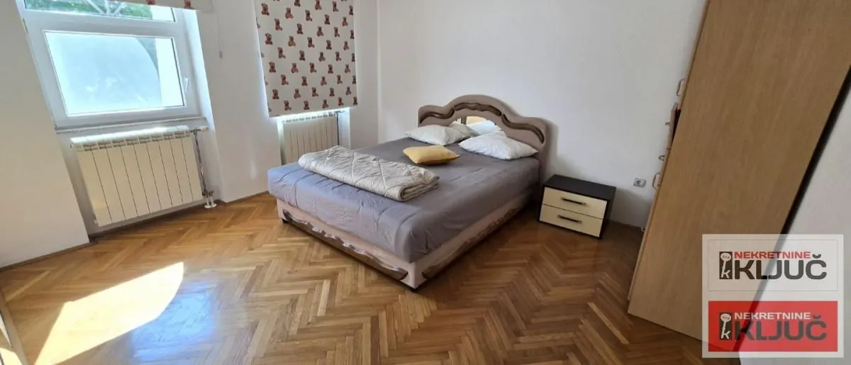 Bedroom with a double bed, parquet flooring, and a wardrobe.